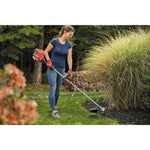 W S 2200 weedwacker 25 C C 2 cycle 17 inch attachment capable straight shaft gas trimmer being used by a person to trim grass.