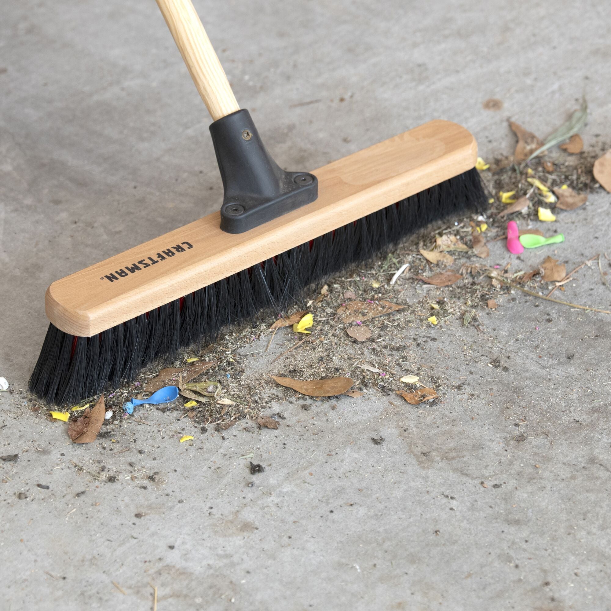 18 inch all-purpose push broom cleaning debris off garage floor