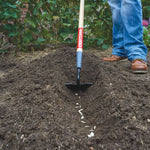 Wood handle planting hoe being used.