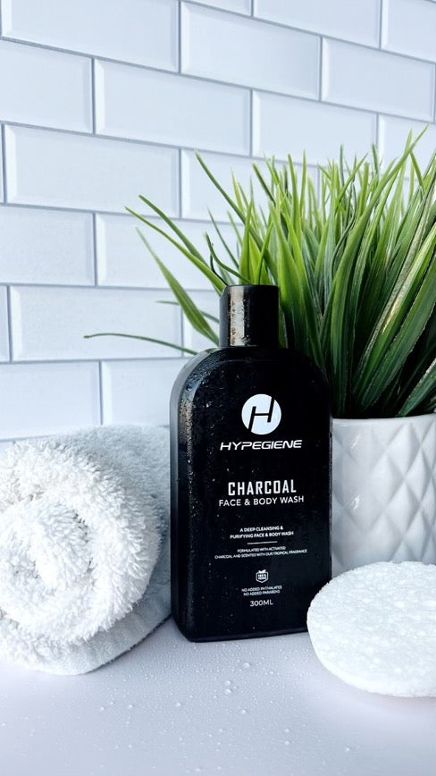 A bottle of Hypegiene Charcoal Face and Body Wash in a clean and fresh white bathroom