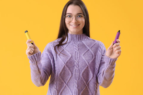 A girl holding two Disposable vapes in her hand for charging