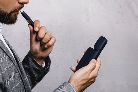 A guy checking the battery of his disposable vape device