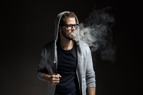 A guy holding a vape pen in his hand