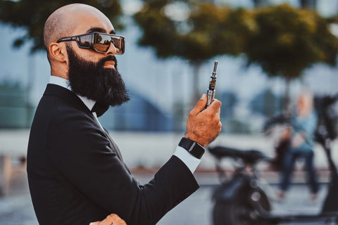 A guy holding cookies vape pen outdoors