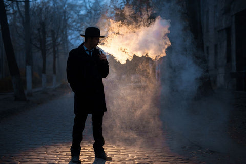 A guy vaping outdoors 