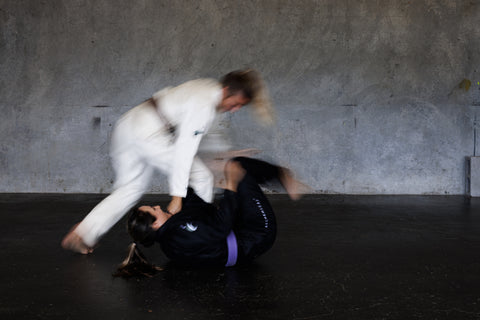 Two woman rolling wearing alchemical movements hemp Gi's.