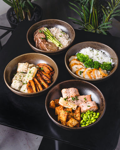 Four bowls of healthy food containing lean meats, green vegetables, and nutritious carbohydrates. Possibly food a nutritionist may recommend to those with chronic obesity and other health issues.