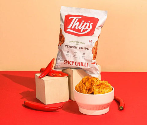 thips tempeh chips snack taken in red background with chili in front, corporate gift boxes, office gift boxes, corporate snack box, office snack box, pantry snack, healthy snacks, gift box, snack box, delivery, pantry snacks, singapore, office gifting, office snacks
