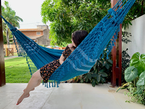 Girl in a dress laying in a hammock in Maceio Brazil.