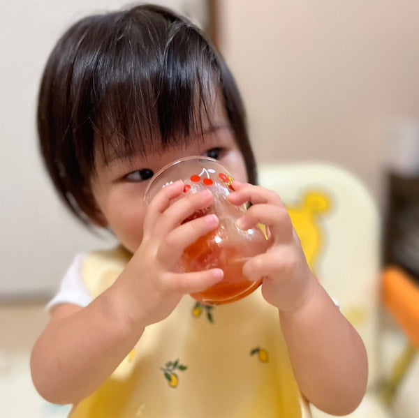 トマトジュースを飲む幼児