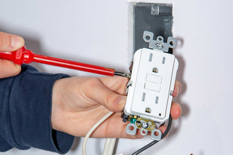 An electrician installing a GFCI outlet.