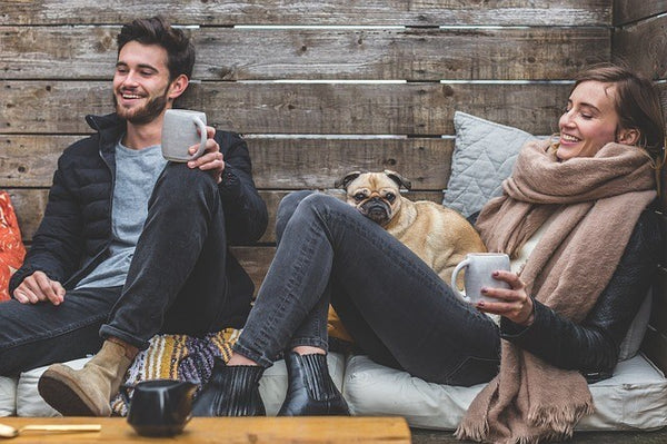 man and woman with a dog drinking coffee