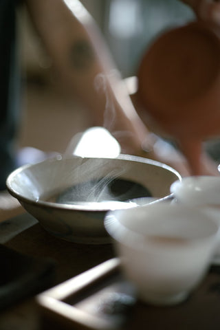 Gongfu tea ceremony, steam rising over bowl