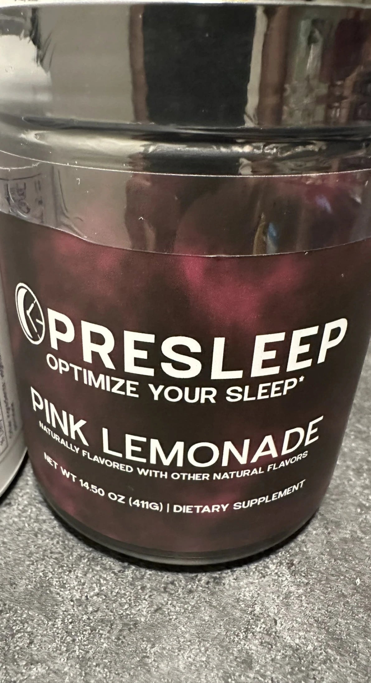 Two jars of 'Presleep' blue raspberry dietary supplement on a kitchen counter.