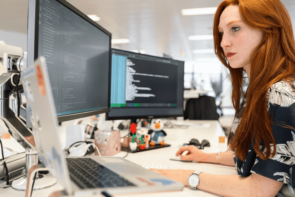 Woman working on computer at desk in office