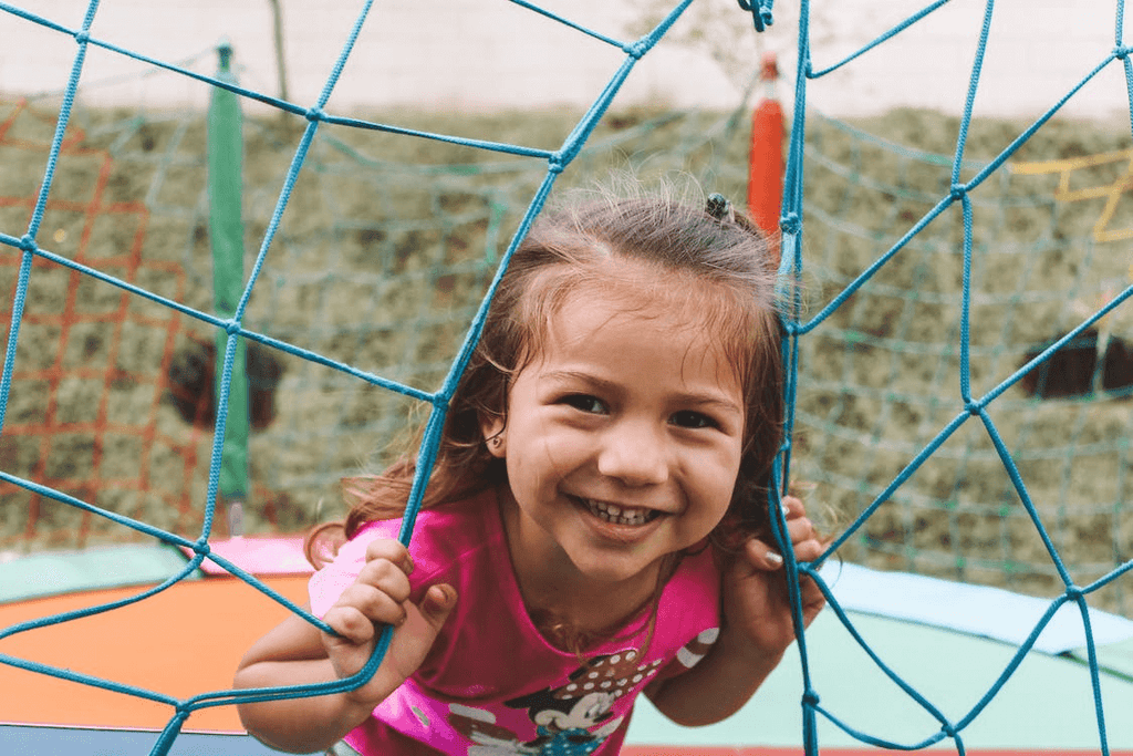 Young girl in pink shirt smiling on the playground