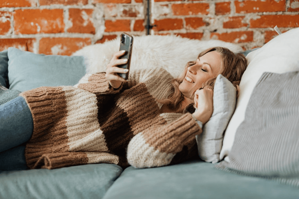 Woman laying on the couch with phone
