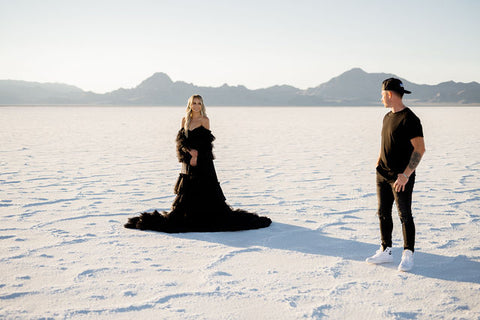 Couple looking at each other at the Salt Flats in a salt gown dress at sunset