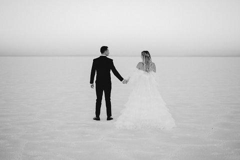 engaged couple holding hands at the salt flats black and white photo in utah