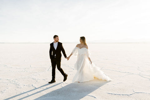newly engaged couple walking through the Salt Flats wearing formal attire during engagement session