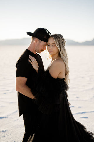 Utah elopement photographer captures woman wearing black dress and man wearing black tshirt and hat during utah engagements