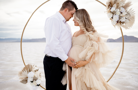 maternity photos with husband in long dress, both holding her baby bump