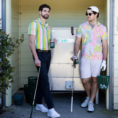 Two golfers standing with a bucket of golf balls at the golf ranch