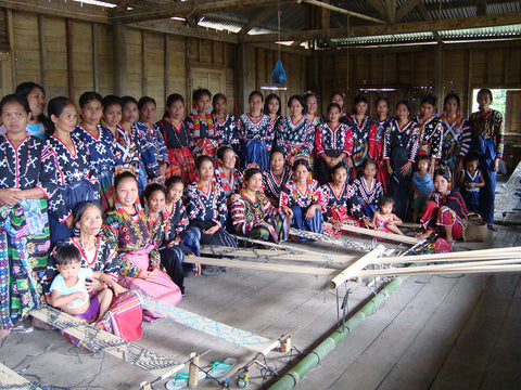 A group photo of  woman of The T’boli Tribe in the Philippines gathered in their workplace where they weave fabric