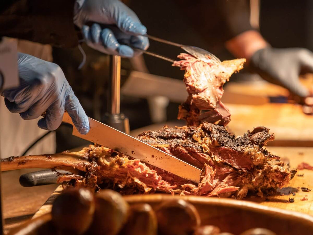 A plate of brisket with mashed potatoes and red wine