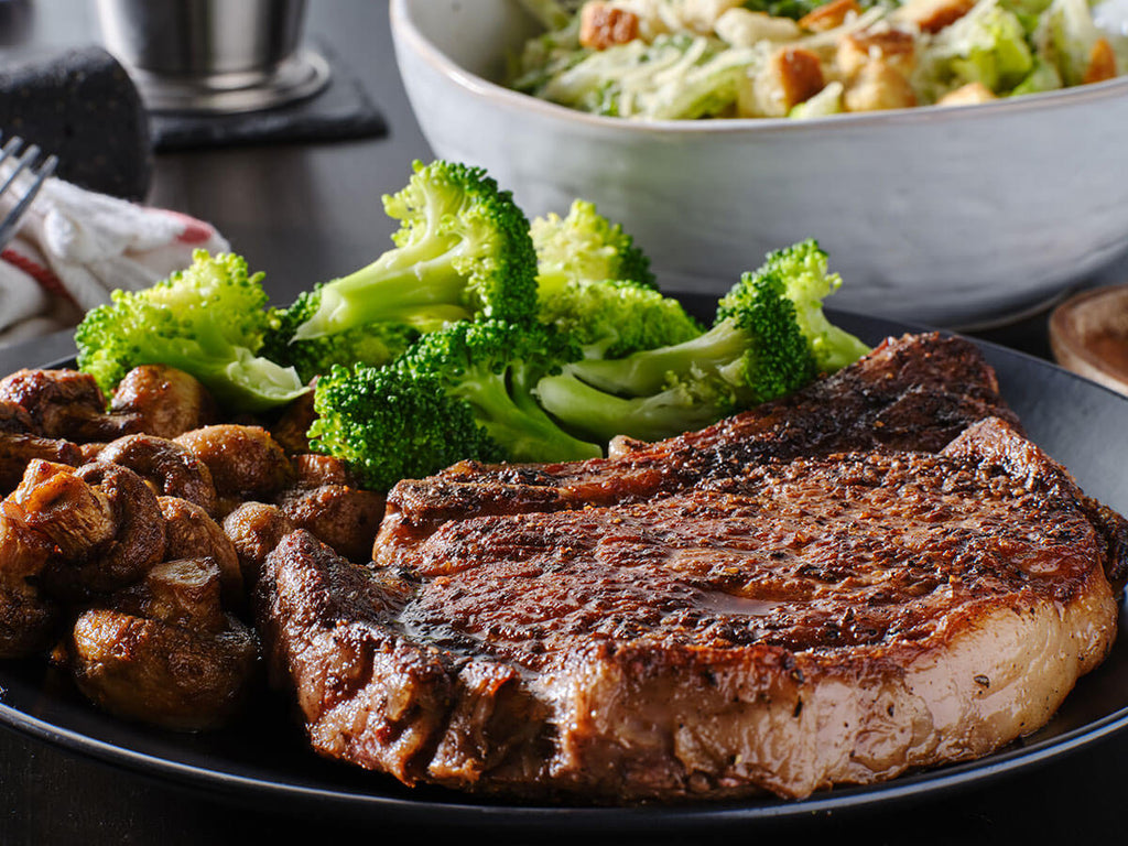 A plate with a Kansas City Strip Steak and a Ribeye Steak