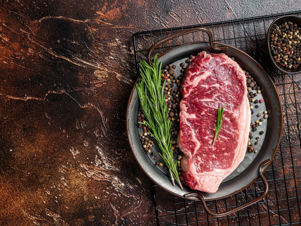 A plate with a New York Strip Steak with Salt and Pepper seasoning