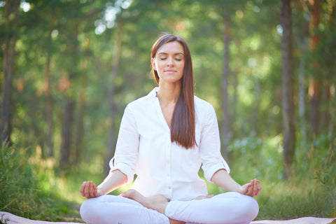 une femme en pleine méditation dans la nature