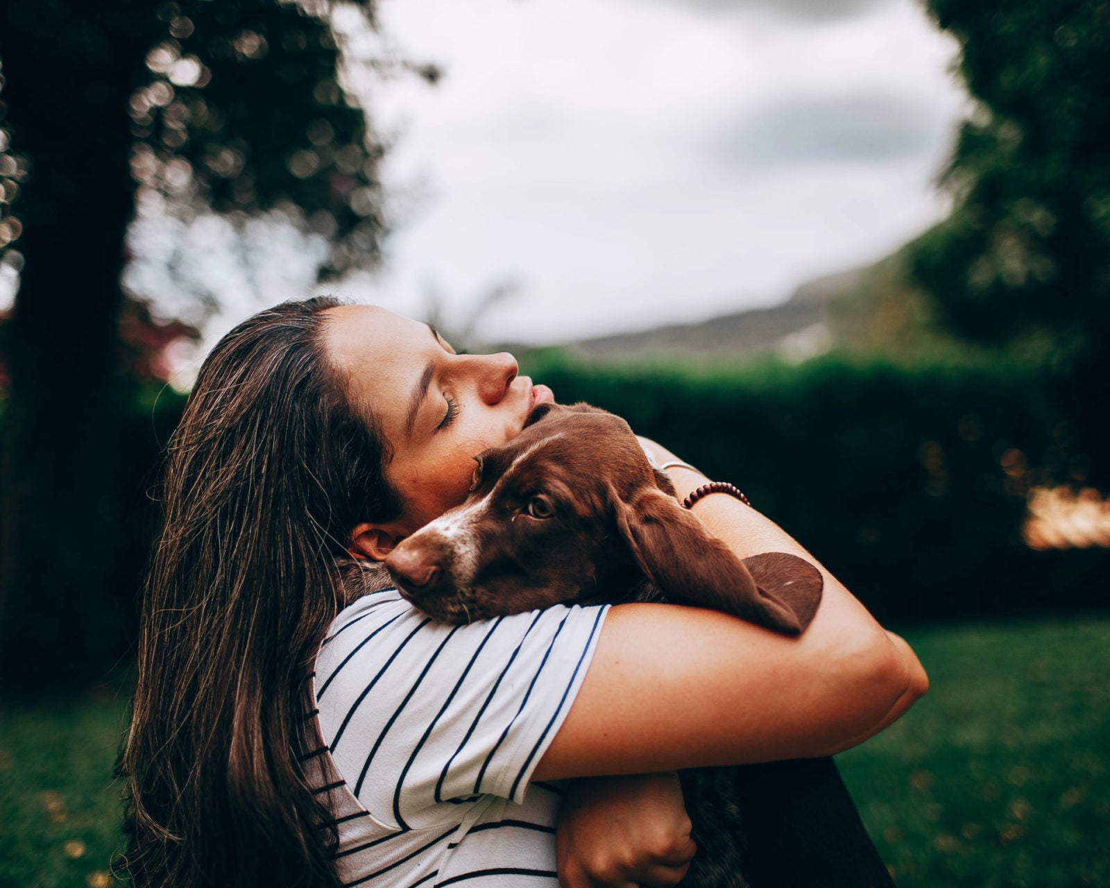 girl hugging her dog senior dog feeding