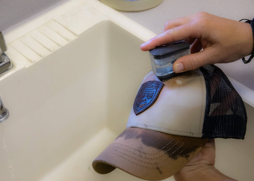 Baseball cap being hand-washed with with SUDS