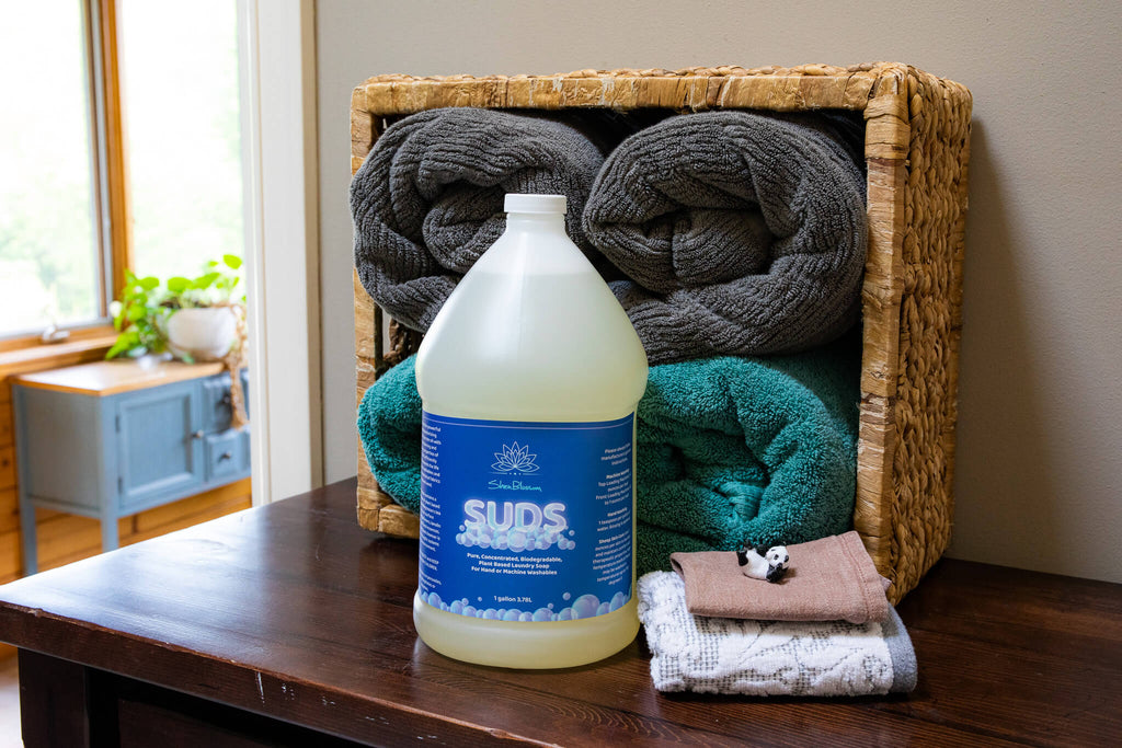 Bottle of SUDS with clean laundry