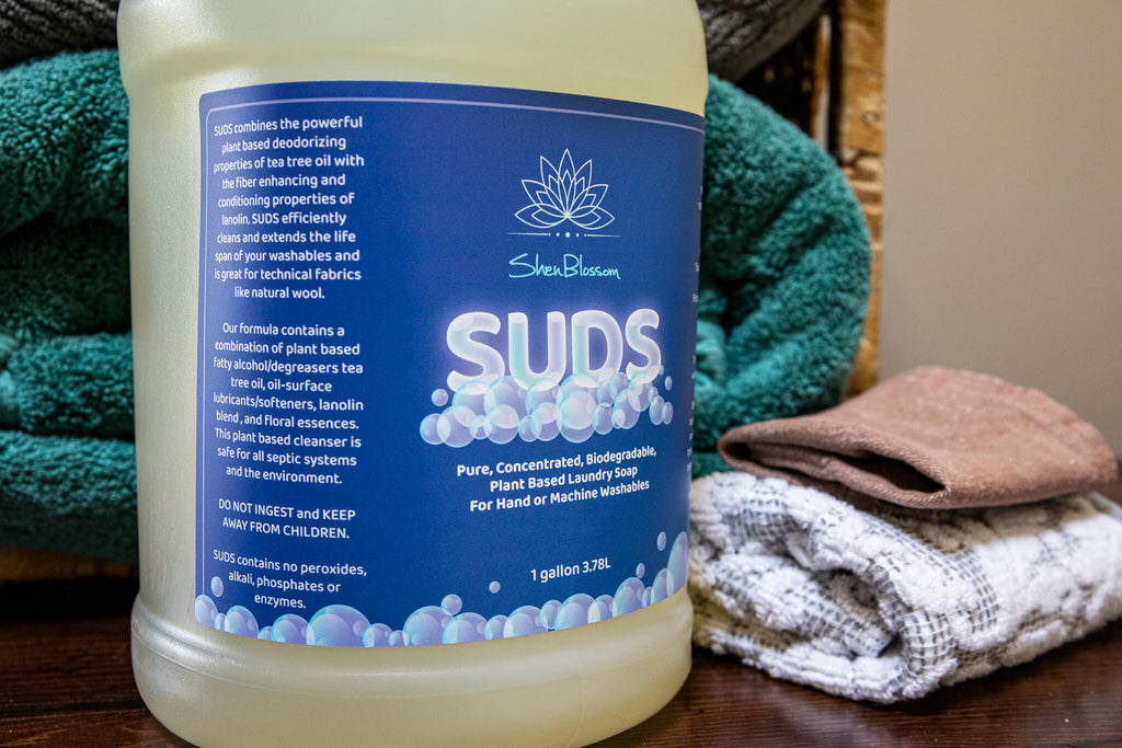 Bottle of SUDS with clean laundry