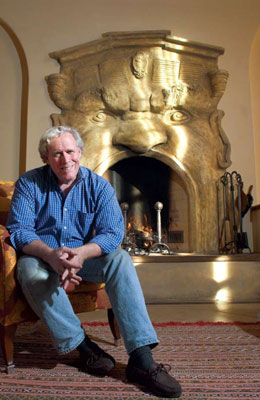 Dennis and a gargoyle fireplace he built in one of the houses he designed.