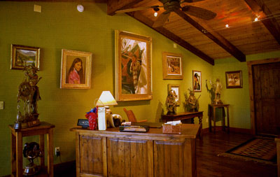 Coleman's studio is filled with his own artwork and that of his peers, including a painting by the late Ray Swanson (center) flanked by a portrait by Don Crowley.