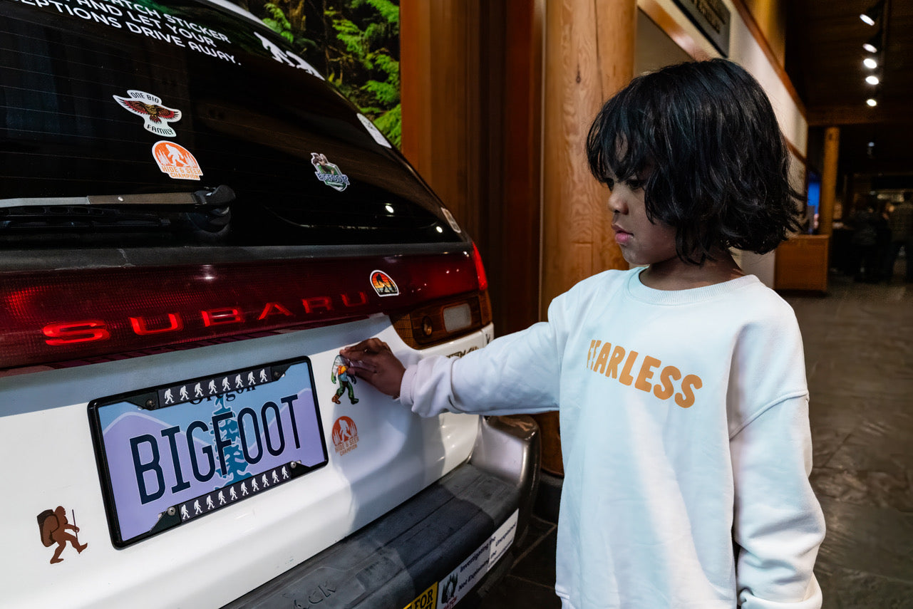 “Bring-your-own” Bigfoot sticker car bumper installation outside 'Sensing Sasquatch' exhibition at High Desert Museum in Bend, OR. Photo by Todd Cary.