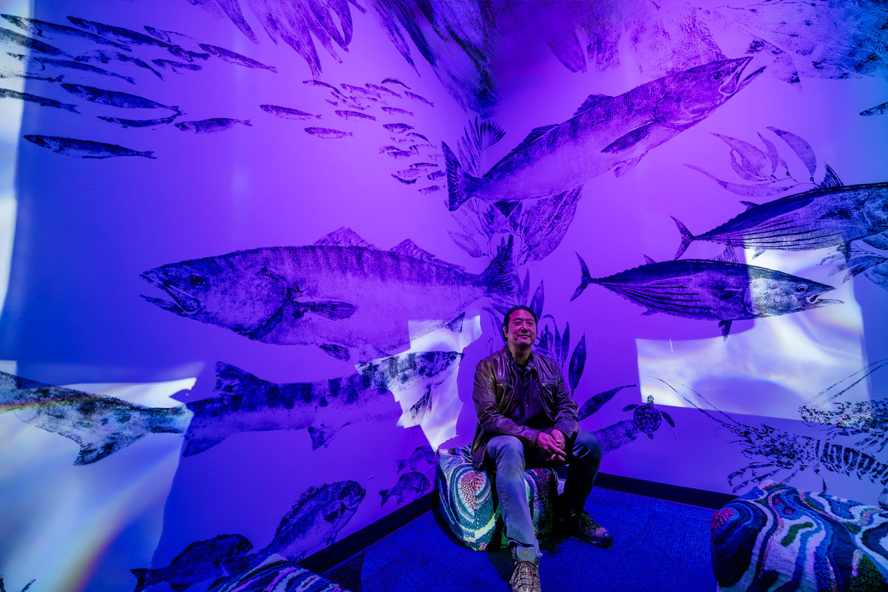 Dwight Hwang in front of his Gyotaku prints at Birch Aquarium.