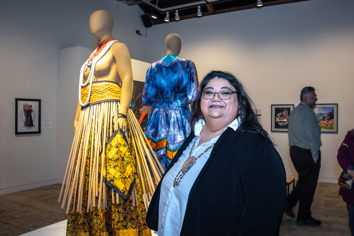 Meyo Marrufo with one of her dress designs at exhibition opening for We Are Still Here Pomo Artists and Our Cultural Landscape at the Sonoma Valley Museum of Art