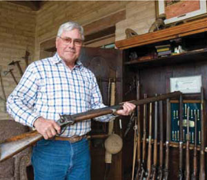 Fred handles one of the many classic rifles, pistols and buffalo guns he has collected over the years. Many of the guns have colorful history, including one specimen used at the Battle of the Little Big Horn. Early in his career, Fred used to exchange paintings for guns, which he later traded for cash. Then he started to repair and eventually build his own collection.