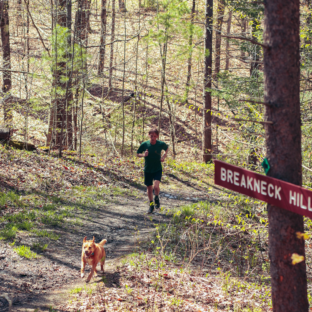 man running on a trail with a dog