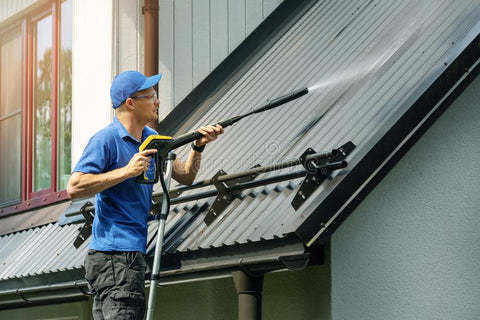 A man power washing his house