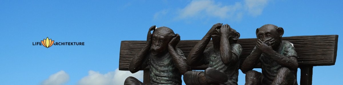three statues of ignorant monkeys sitting on a bench