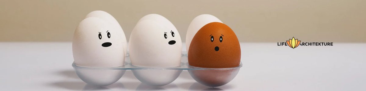 zwei weiße Eier und ein braunes Ei mit einem Smiley darauf