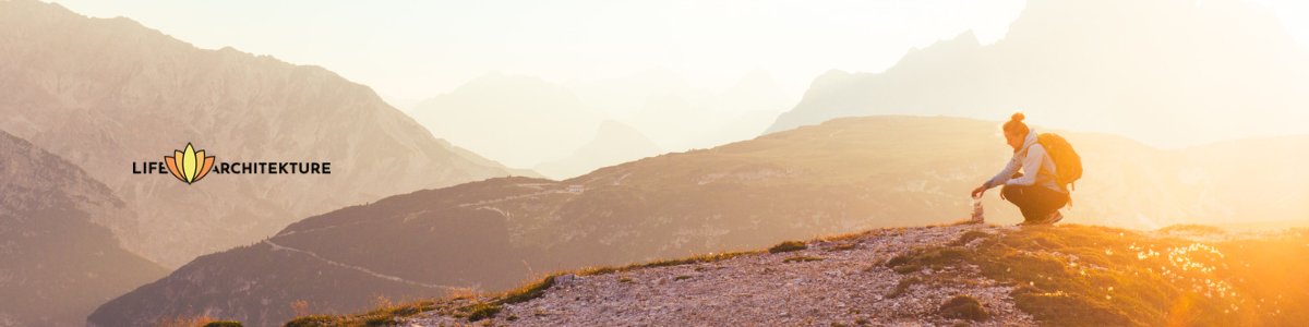 mountains sunset with a man putting rocks on top of one other