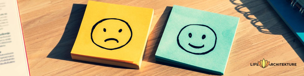 two post-it on a desk, one yellow with sad smiley, other blue with happy smiley