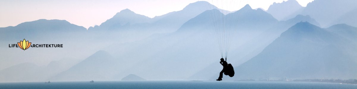 paragliding with misty mountains and water in the background