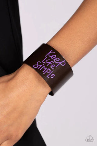 Image of "Simply Stunning - Purple" snap bracelet worn on a woman's arm with hand resting on hip. Inscribed with phrase "Keep Life Simple."